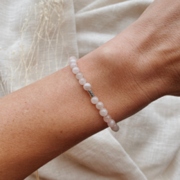 A delicate rose quartz bracelet with a simple, elegant design. The bracelet features small, round rose quartz beads strung together on a thin, flexible cord, creating a minimalist and feminine accessory.