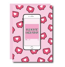 A pink greeting card with a smartphone displaying the text "I really like you" against a background of red heart shapes.