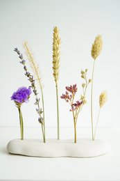 Ceramic holder with assorted dried flowers including lavender, wheat, and other natural elements.