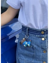 Handmade and hand-painted keychain featuring a dog in a floral design. Made of durable materials, this unique accessory is perfect for pet lovers.