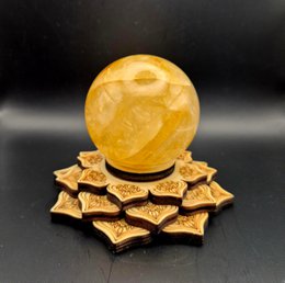  Wooden sphere holder in lotus shape for crystal gift, available in big 12cm and small 7cm sizes. The holder features a round yellow crystal sphere resting on a decorative wooden lotus-shaped base.