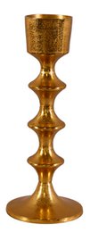  A tall, gold-colored candle holder with a decorative, textured surface. The candle holder has a classic, elegant design and would make a beautiful addition to any home decor.