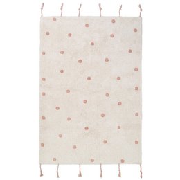 A soft, plush children's rug with a polka dot pattern in shades of pink and nude. The rug features tassels along the edges for a decorative touch.