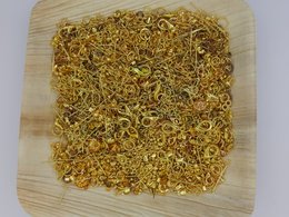 A collection of assorted metal jewelry making components in various shapes and sizes, including rings, loops, and other decorative elements in a golden color.