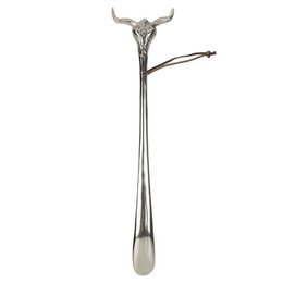 A long, silver-colored metal shoehorn in the shape of a skull with horns, measuring approximately 52 cm in length.