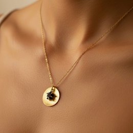  Gold pendant necklace with a black star design, made of high-quality materials.