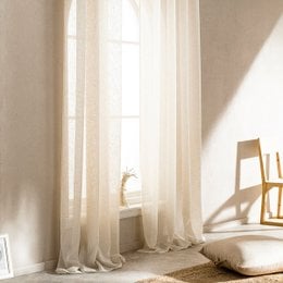 Beige curtain panels, 140cm x 280cm, made of a lightweight, sheer fabric that allows natural light to filter through. The curtains have a simple, minimalist style that would complement a variety of home decor styles.