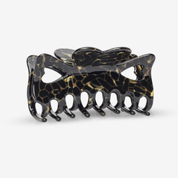  Black and gold hair clip with a decorative, abstract design.