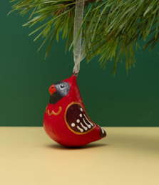 Handmade papier-mache winter bird ornament in the shape of a red cardinal with detailed features.