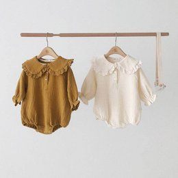 Collared linen bloomers in cream-white and ochre brown colors, available in sizes 3-6M, 6-12M, 12-18M, and 18-24M. The bloomers feature a collared neckline and puff sleeves, made from a soft linen material.