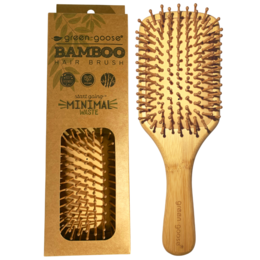 A large, oval-shaped bamboo hairbrush with natural bristles. The brush has a wooden handle and is designed for detangling and smoothing hair.