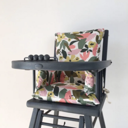 Floral patterned cushion for a baby highchair, featuring a colorful abstract design with pink, green, and yellow elements.
