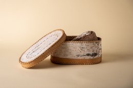 A white, rectangular bread box made of woven material with a hinged lid. The box has a natural, rustic appearance with visible woven patterns and textures.