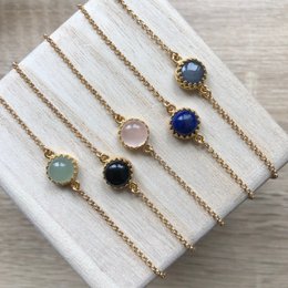 The Margaux natural stone bracelet is a beautiful piece of jewelry featuring a variety of semi-precious stones in different colors, including aventurine, labradorite, lapis lazuli, onyx, rose quartz, moonstone, tiger's eye, and amazonite. The bracelet has a delicate gold-toned chain and the stones are set in a simple, elegant design, making it a versatile accessory that can be worn for both casual and formal occasions.