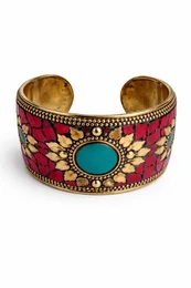"Wide cuff bangle bracelet with ornate gold detailing, colorful gemstone center, available in red and blue"