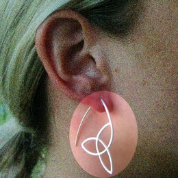 Oval-shaped statement earrings with a minimalist, modern design featuring a triple-loop pattern in a metallic finish.