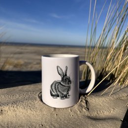 A white ceramic mug featuring a detailed illustration of a starfish against a blue background, surrounded by seashells and other beach elements.