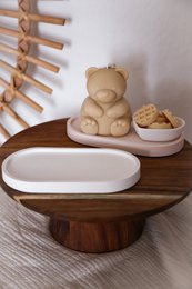  Oval white ceramic tray with a wooden base. The tray features a simple, minimalist design and is suitable for displaying jewelry or other small items.