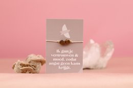  A beaded bracelet with the words "Proud - trust and courage" printed on a tag. The bracelet features a white feather charm, symbolizing trust and courage.