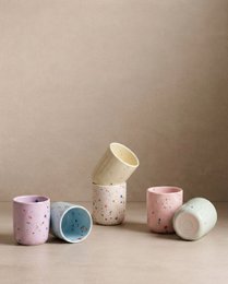 Colorful speckled ceramic egg cups in a variety of pastel shades including blue, green, lilac, pink, yellow, and white. Ideal for serving breakfast or holding small items.