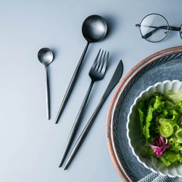 A 32-piece cutlery set in black and gold colors, suitable for 8 people. The set includes forks, knives, and spoons with a modern, minimalist design.
