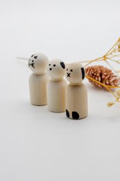 Wooden figurines of a dog, cat, and rabbit in a neutral color palette. The figurines have simple, minimalist designs and appear to be part of a set or collection.