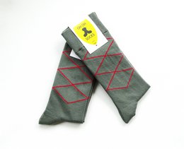 Grey socks with red diamond pattern and yellow logo.