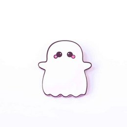A cute, white ghost-shaped brooch with large eyes and a simple expression, surrounded by colorful confetti and glitter on an orange background.