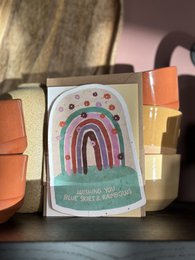 "Colorful postcard with rainbow design and text 'Wishing you blue skies & rainbows'"