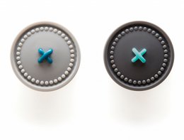  A gray button-up shirt with a turquoise button and a gray button with an X design.