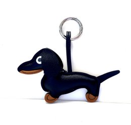 Black and silver dachshund-shaped keychain with a metal ring for attaching to keys or bags.