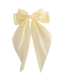 Cream-colored hairpin with a large bow. The hairpin appears to be made of a soft, fabric-like material and has a decorative bow attached to it.