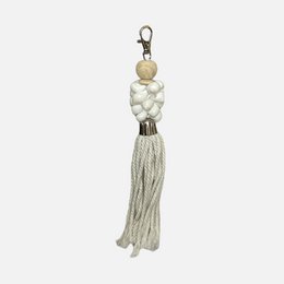 White tassel keychain with beaded accents, suitable for accessorizing or as a decorative item.