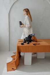 Off-white linen tablecloth, 250x145 cm, with a minimalist floral centerpiece arrangement on a white table.