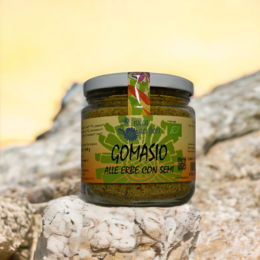 Organic herbal gomasio with chia seeds, a savory seasoning blend in a glass jar with a green label.