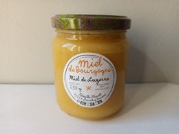 Creamy burgundy alfalfa honey, golden yellow jar, glass container, natural product, 250g