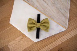 Olive green bow tie for pets, made of soft fabric, suitable for small to medium-sized animals.
