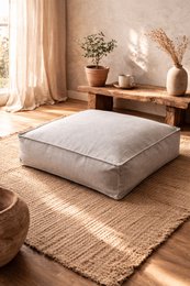 Linen Cru Pouf, a neutral-colored, square-shaped ottoman with a textured linen-like fabric, suitable for use as extra seating or a footrest in a living room or bedroom.