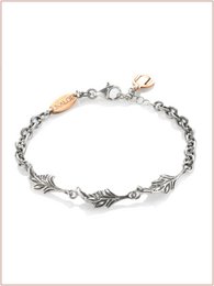  Burnished and gold-toned cuff bracelet with leaf-shaped charms, made of metal.