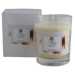 A tall, round candle with a warm, woody scent of oud wood. The candle is encased in a glass container and packaged in a simple, minimalist box.