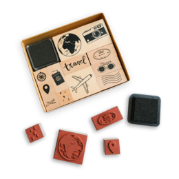 A wooden stamp set with travel-themed rubber stamps, including a globe, airplane, and various travel icons.