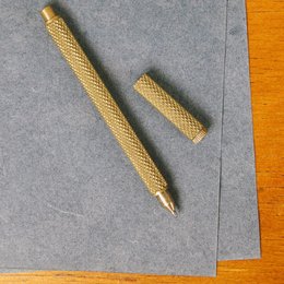 Brass pen with knurled texture, suitable for decorative use.