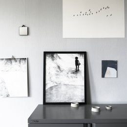 Monochrome screen print depicting a silhouetted figure walking in a minimalist, abstract landscape.