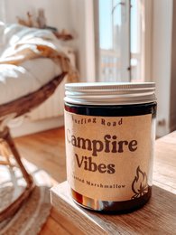 Toasted marshmallow scented candle with a rustic, campfire-inspired design. Features a round, tall shape and a warm, cozy fragrance.