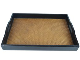 Rectangular black serving tray with woven rattan surface.