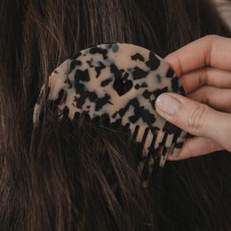  Leopard print hair comb with a round, curved shape.