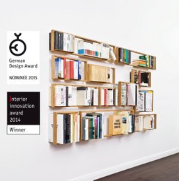 Modular wall-mounted bookcase with various size options, made of wood and metal, suitable for storing books and other items in a home or office setting.