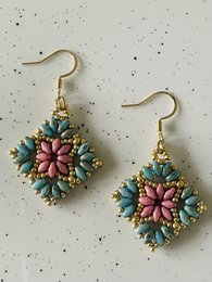  Colorful floral statement earrings with a mix of pink, green, and gold tones. The intricate beaded design creates a bold and eye-catching accessory.