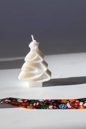 Tall, spiral-shaped white candle with a festive Christmas tree design. Made of soy wax.