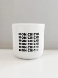 White ceramic mug with repeating "Mon chichi" text pattern.
